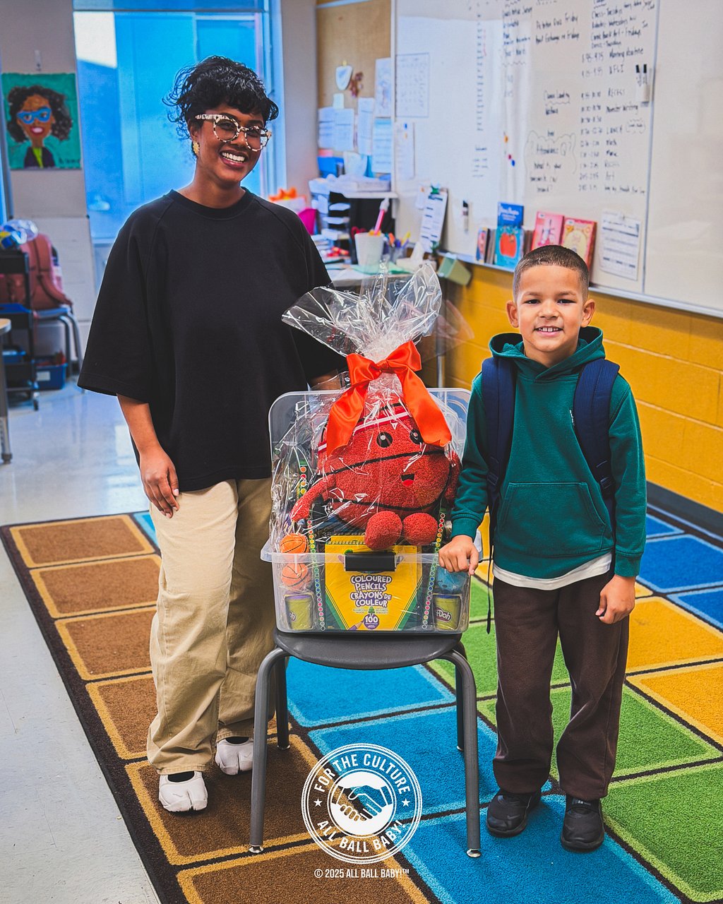 Dre and his teacher with the classroom donation basket