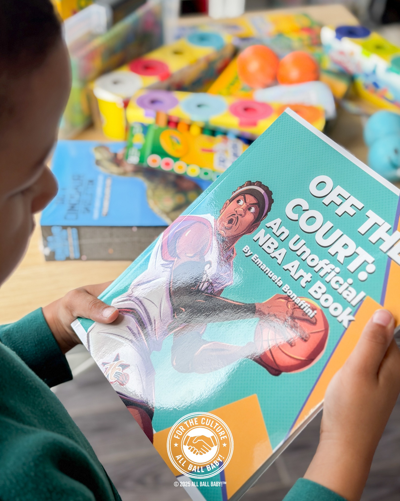 Dre looking through an illustrated basketball art book