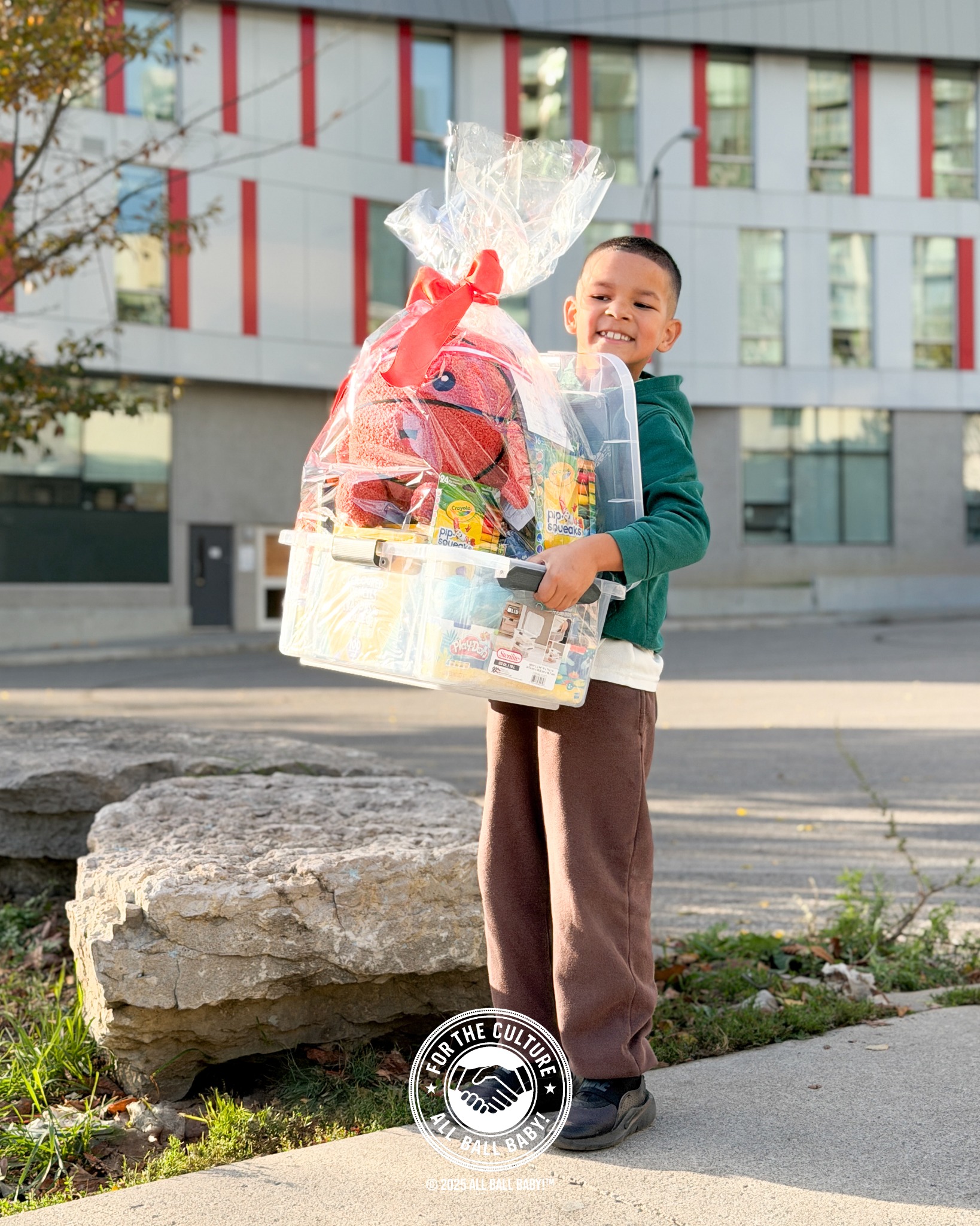 Dre carrying a classroom donation basket outdoors