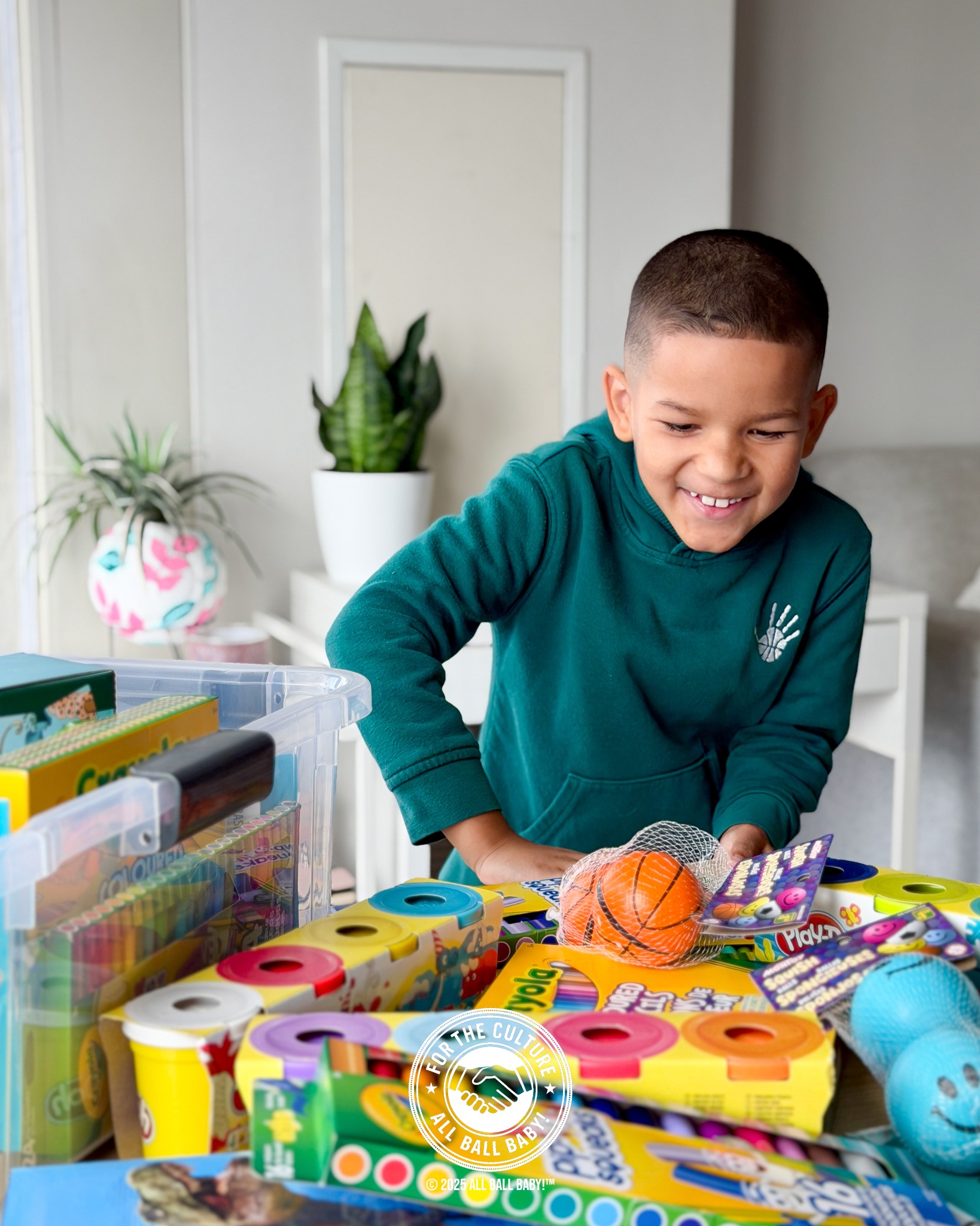 Dre smiling while arranging art supplies and basketball gifts